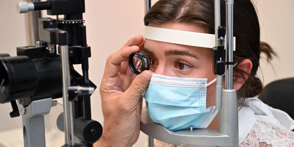 Patient looking through lens in eye test